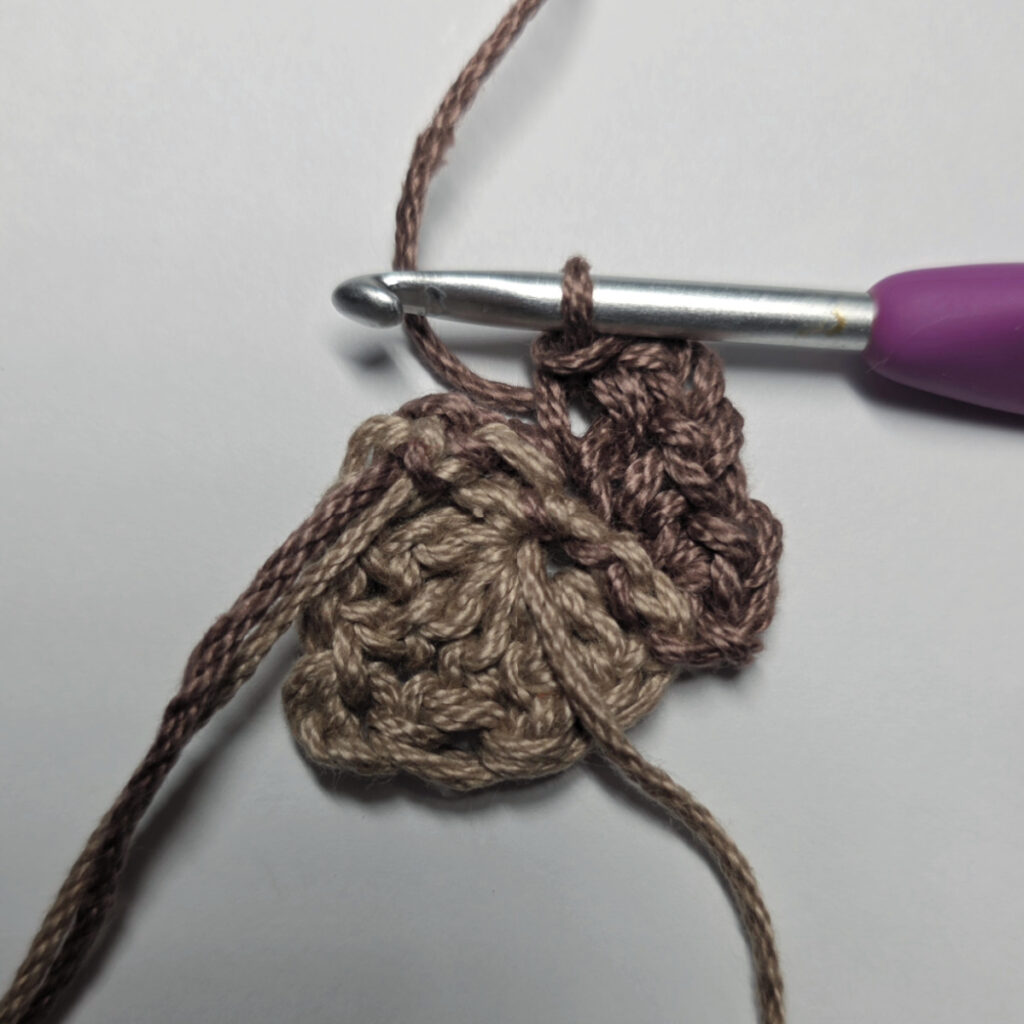 Making a crochet acorn with brown yarn.