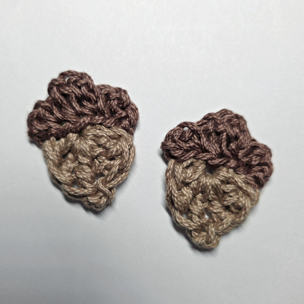 Two crochet acorns against a white background.