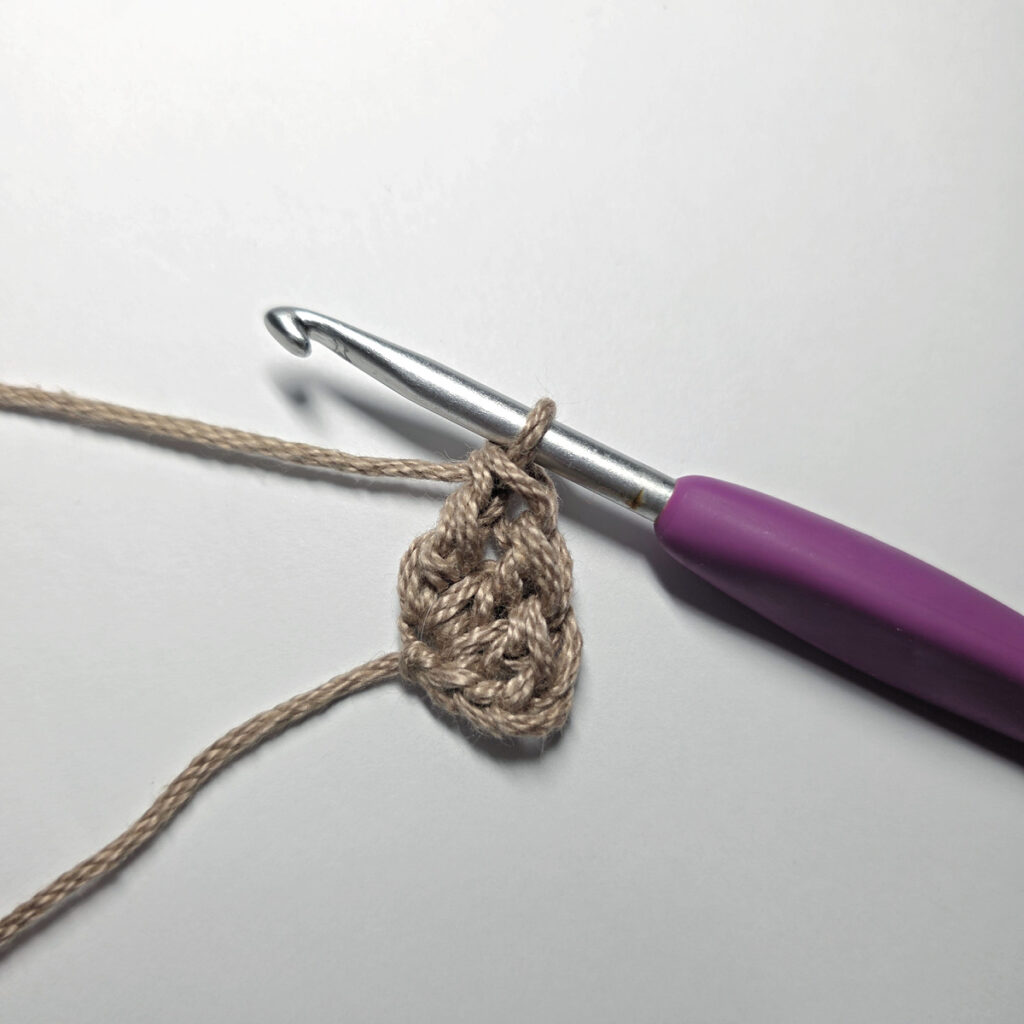 Making a crochet acorn with brown yarn.