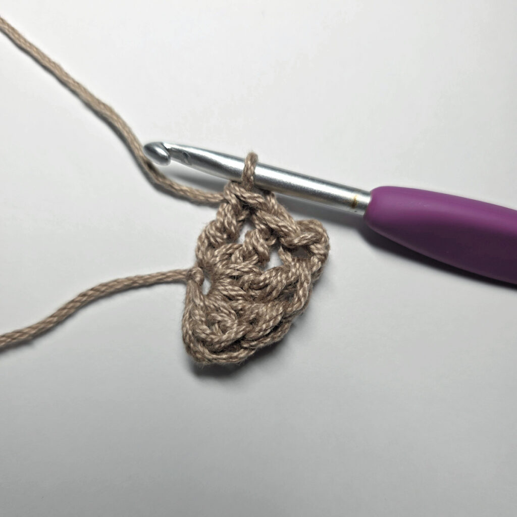 Making a crochet acorn with brown yarn.