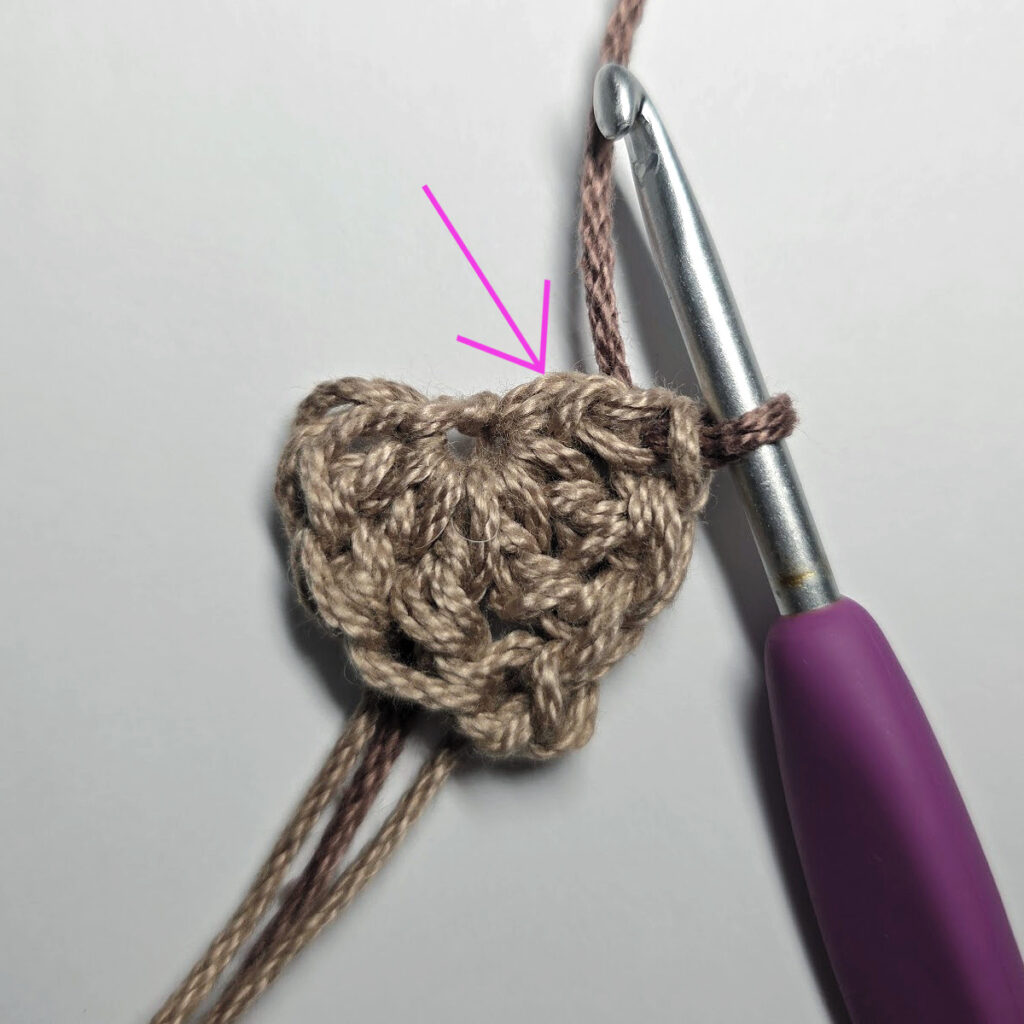 Making a crochet acorn with brown yarn.