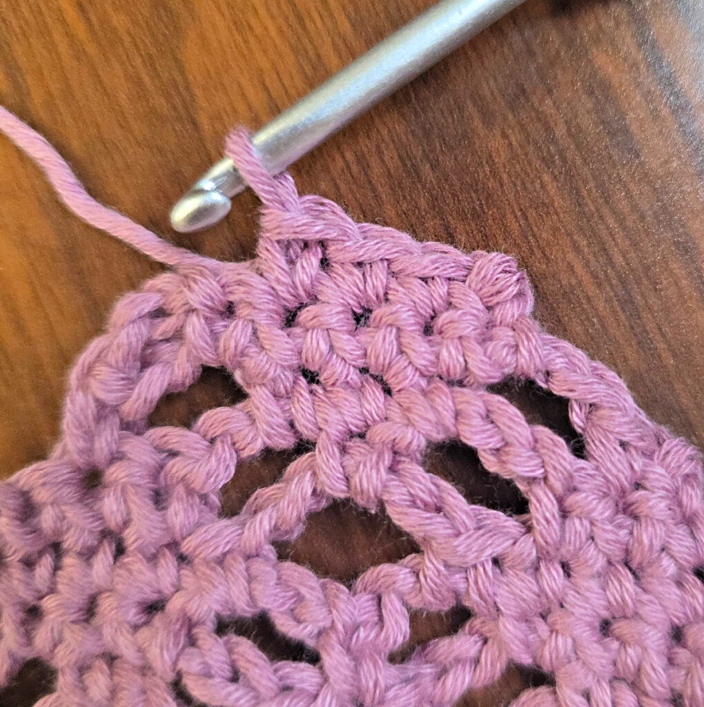 Making a crochet head scarf with a purple crochet hook.