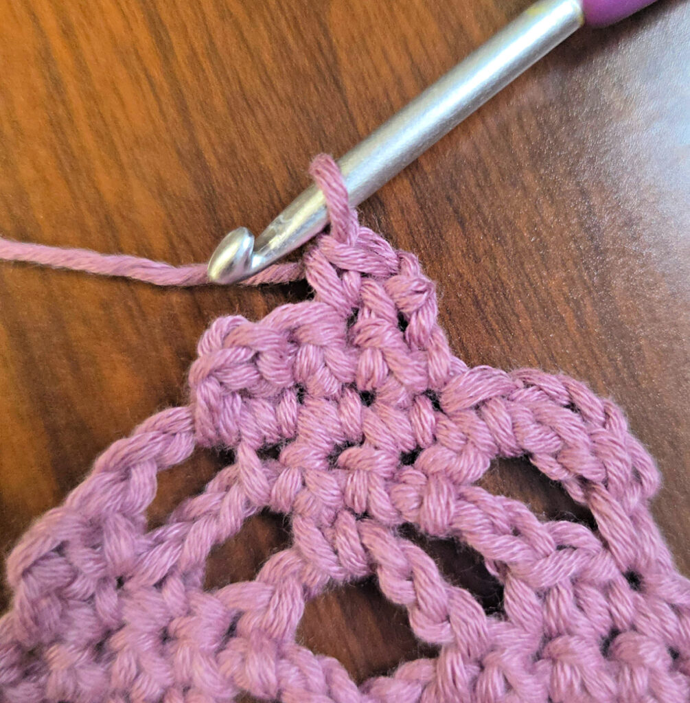 Making a crochet head scarf with a purple crochet hook.