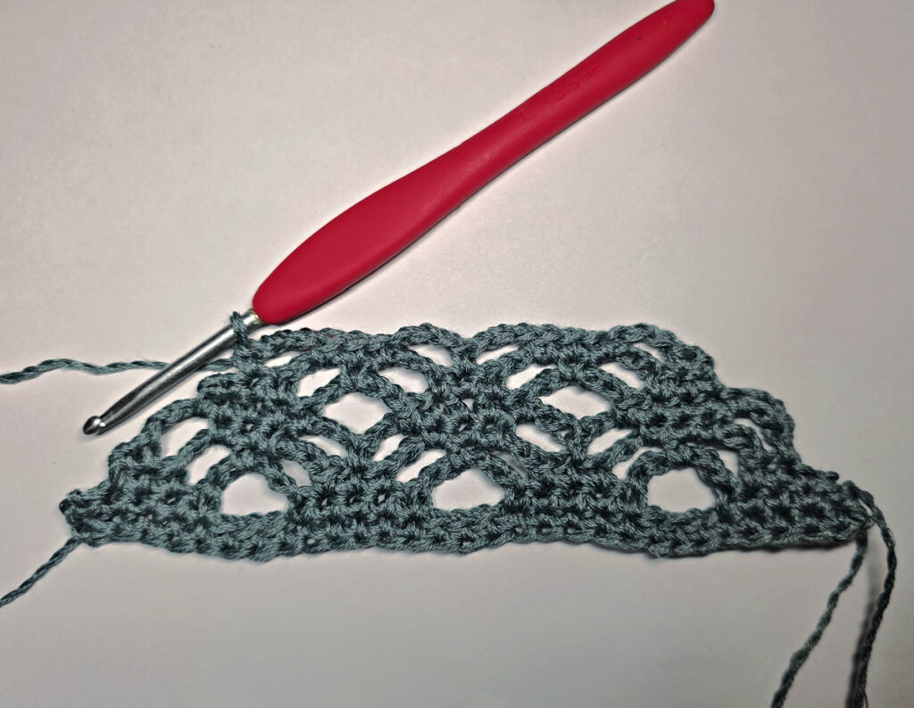 Making a crochet bandana with a red crochet hook.