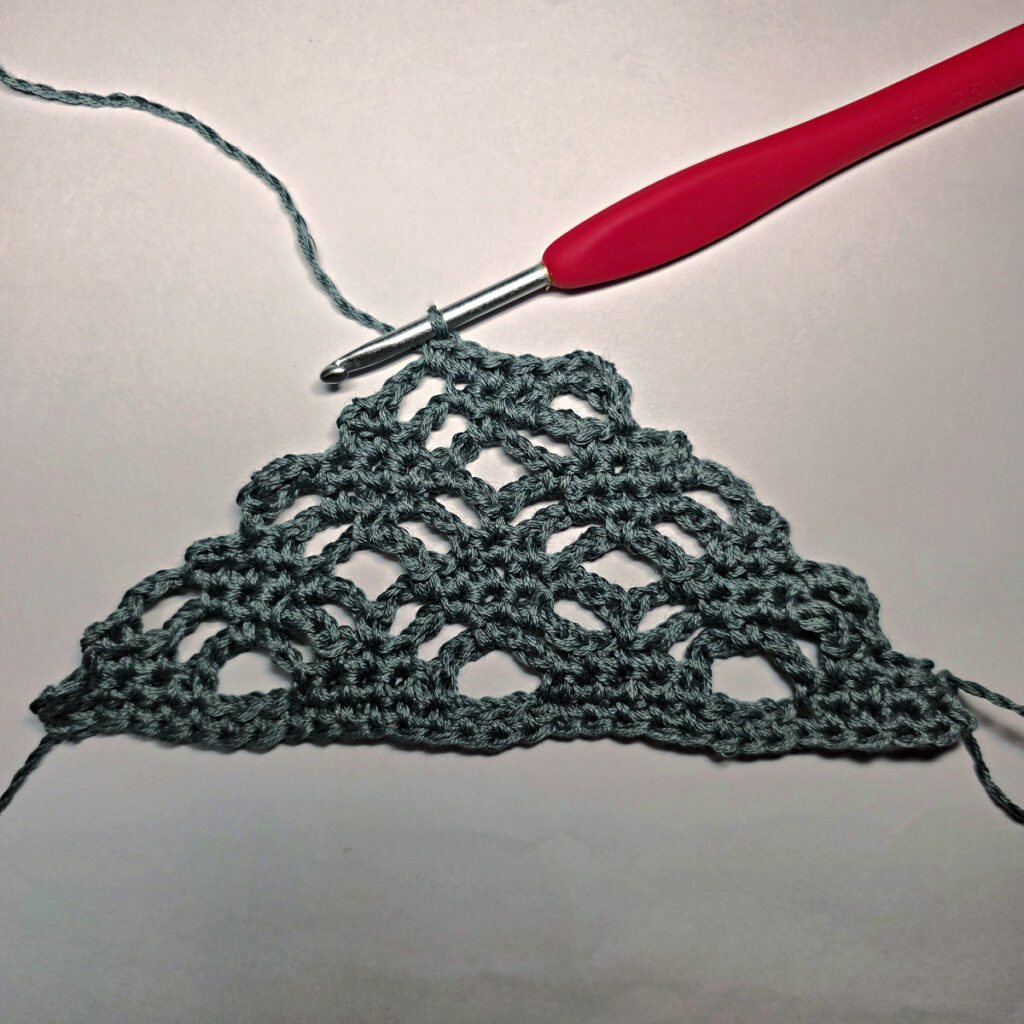 Making a crochet bandana with a red crochet hook.