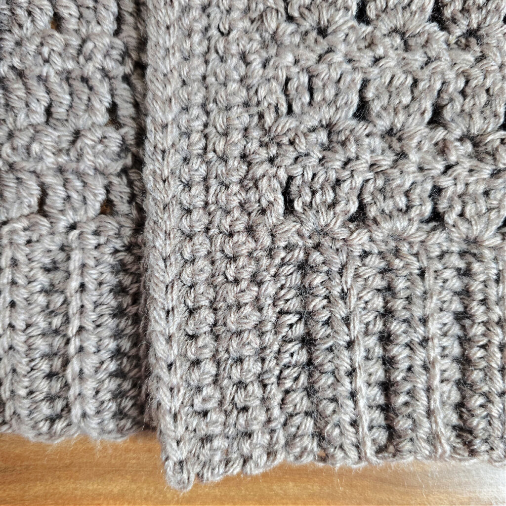 A close up photo showing the surface crochet used to stabilize the opening edge of the cardigan.