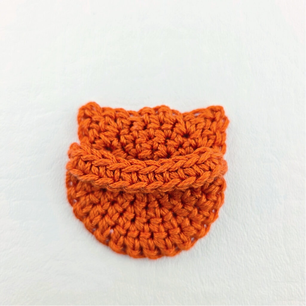 An orange crochet cat bookmark.