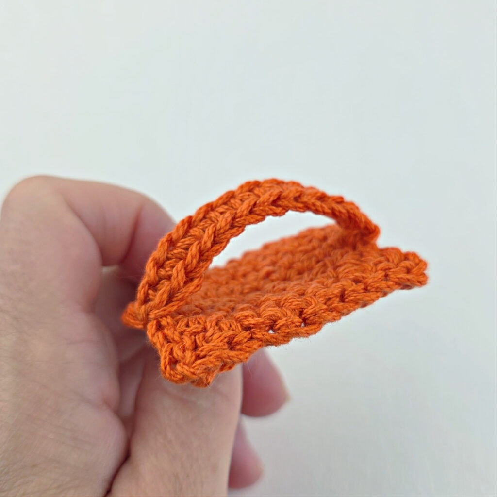 An orange crochet cat bookmark.