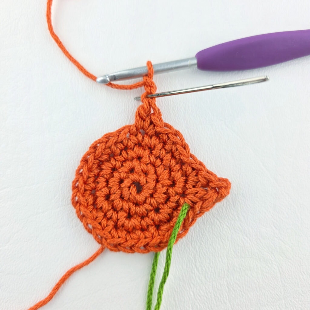 Making an orange cat crochet bookmark with a purple hook.