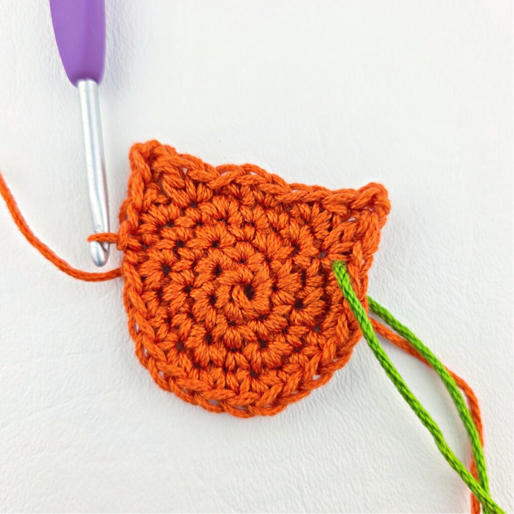 Making an orange cat crochet bookmark with a purple hook.