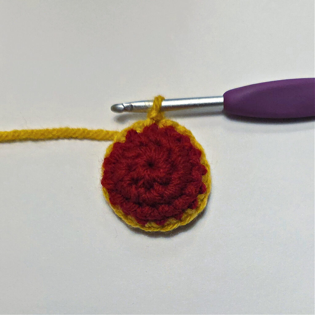 A red crochet circle with a gold edging.