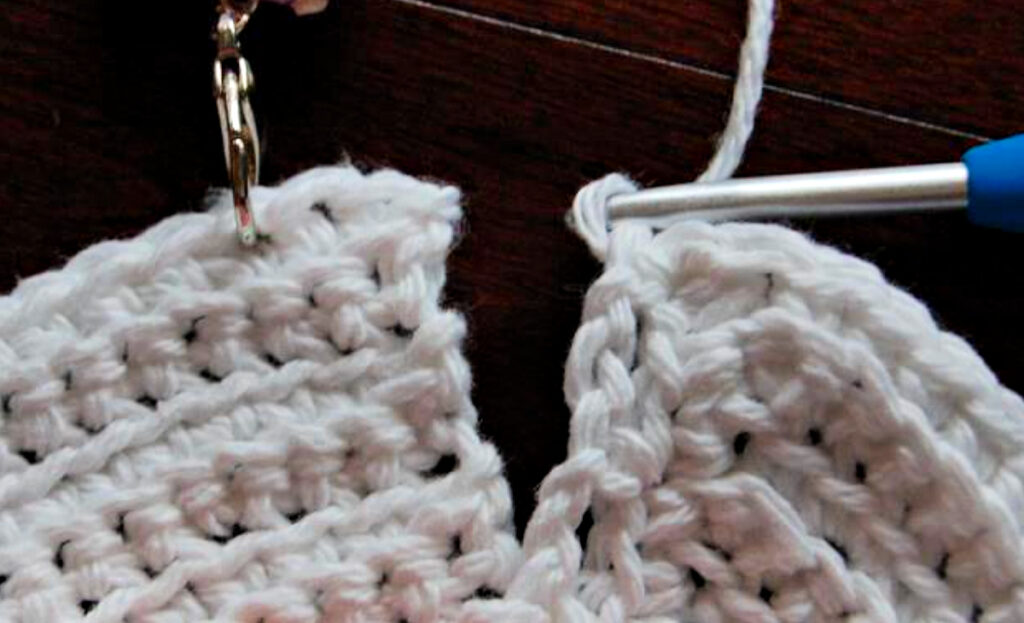 Crocheting the yoke of a doll dress.