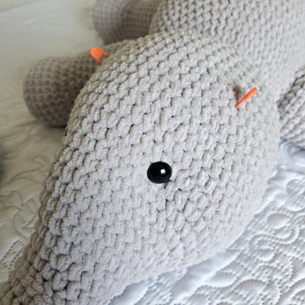A gray crochet elephant head in progress.