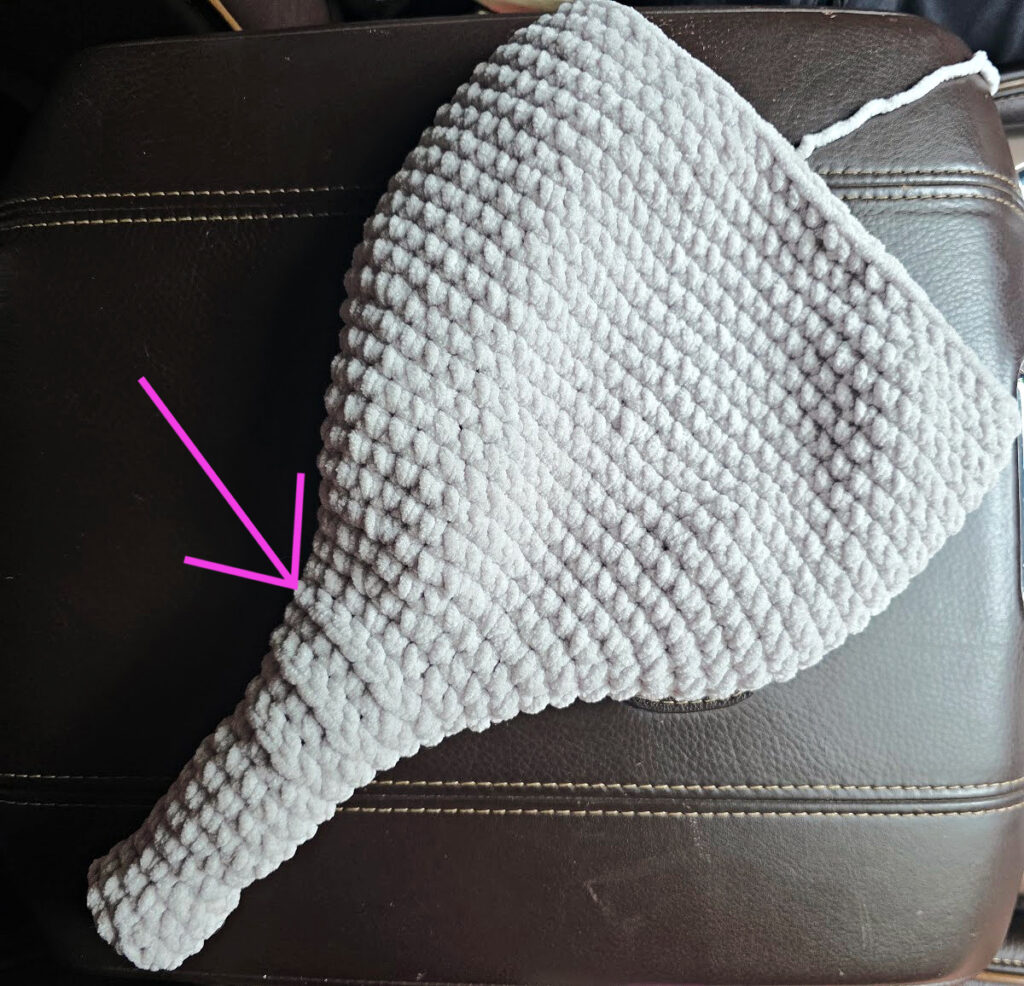 A gray crochet elephant head in progress.