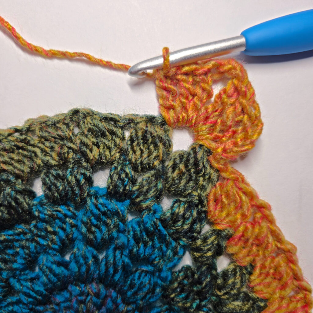 How to work a crochet floral square with a blue crochet hook.