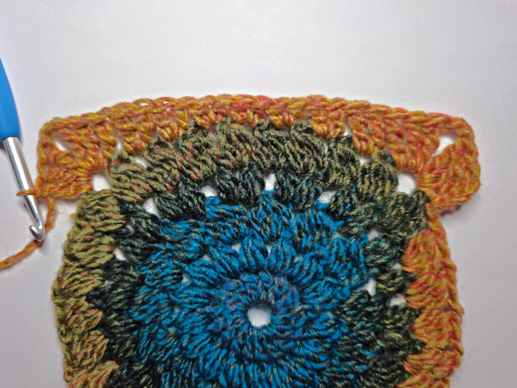 How to work a crochet floral square with a blue crochet hook.