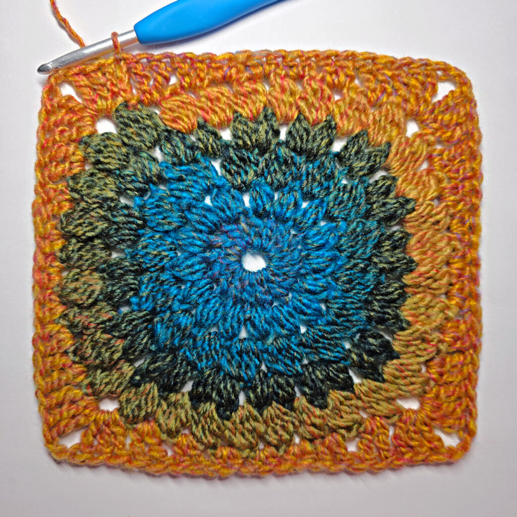 How to work a crochet floral square with a blue crochet hook.