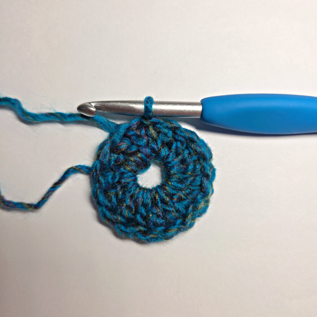 How to work a crochet floral square with a blue crochet hook.