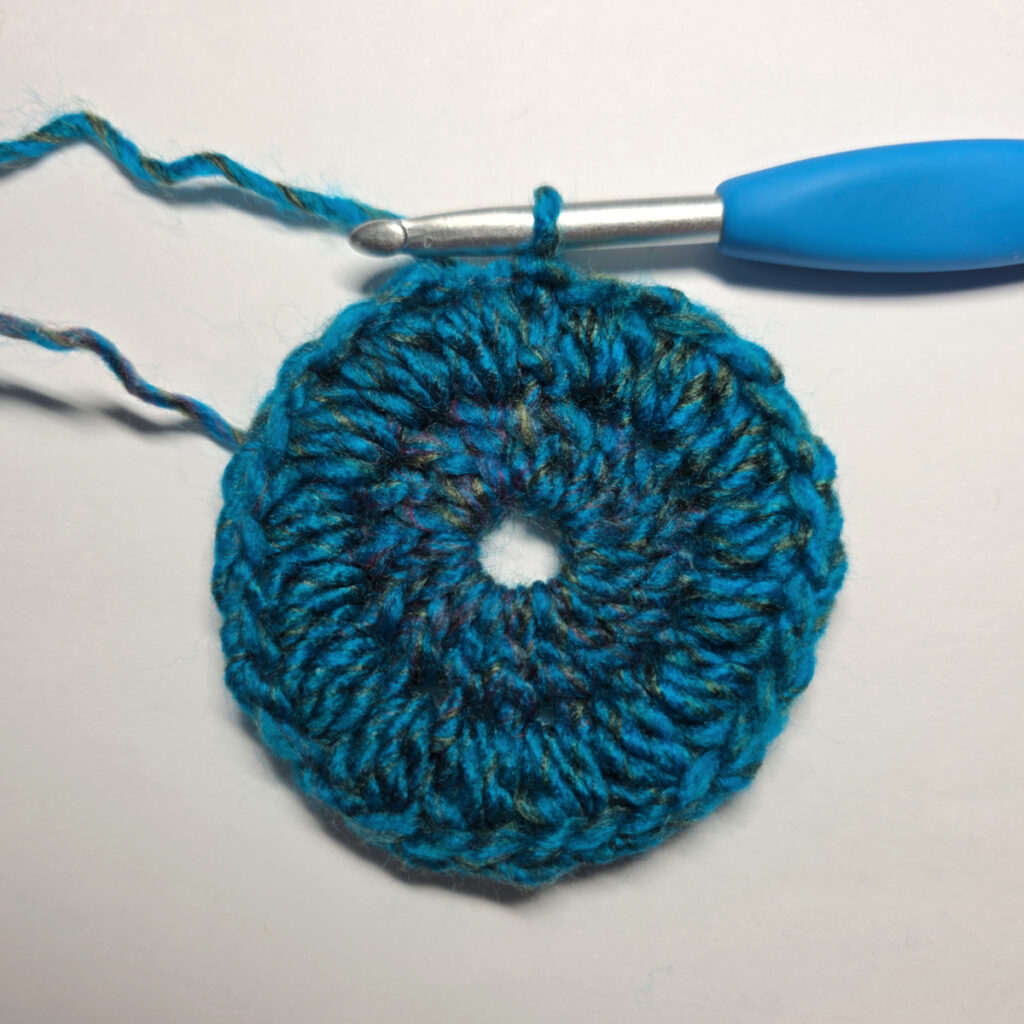 How to work a crochet floral square with a blue crochet hook.