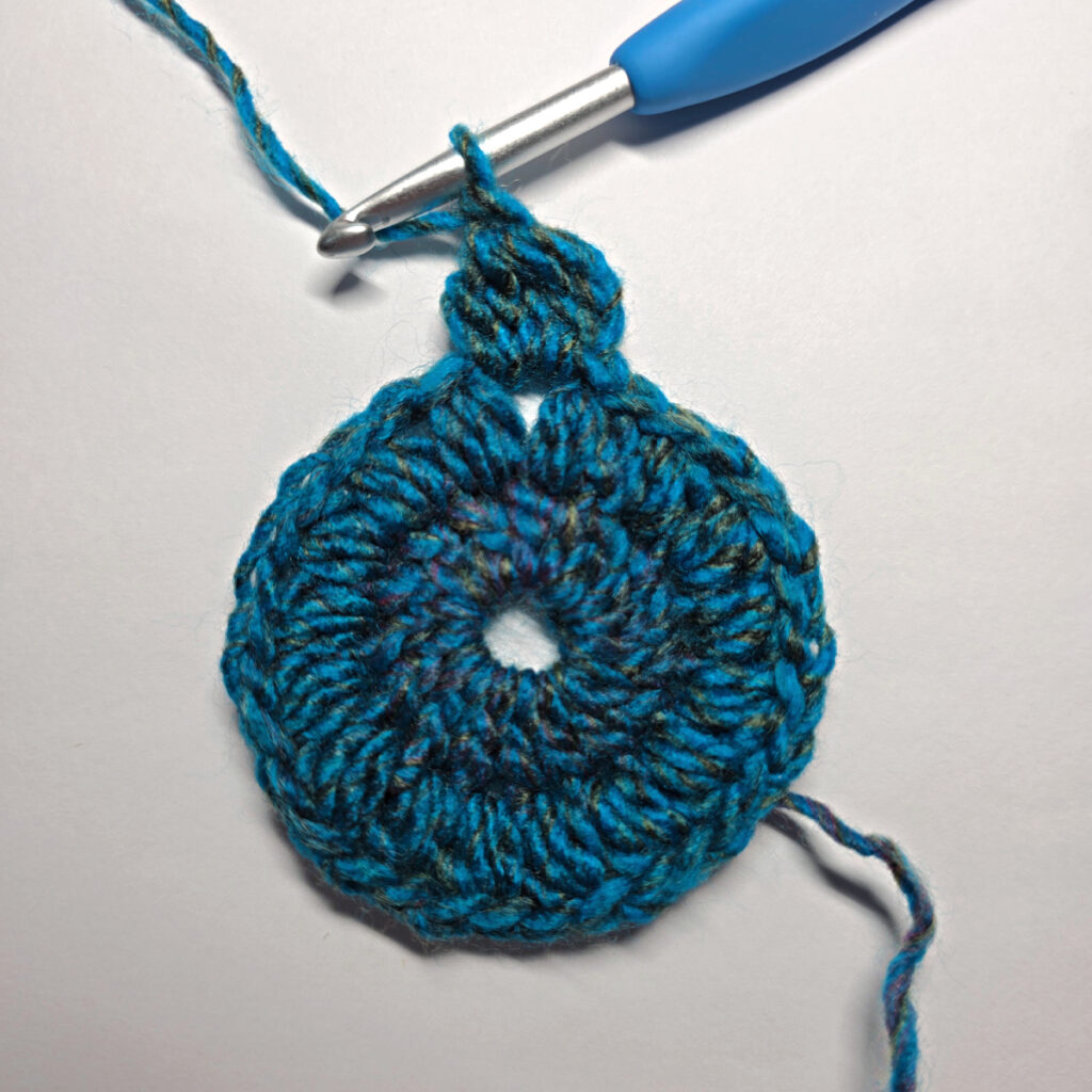 How to work a crochet floral square with a blue crochet hook.