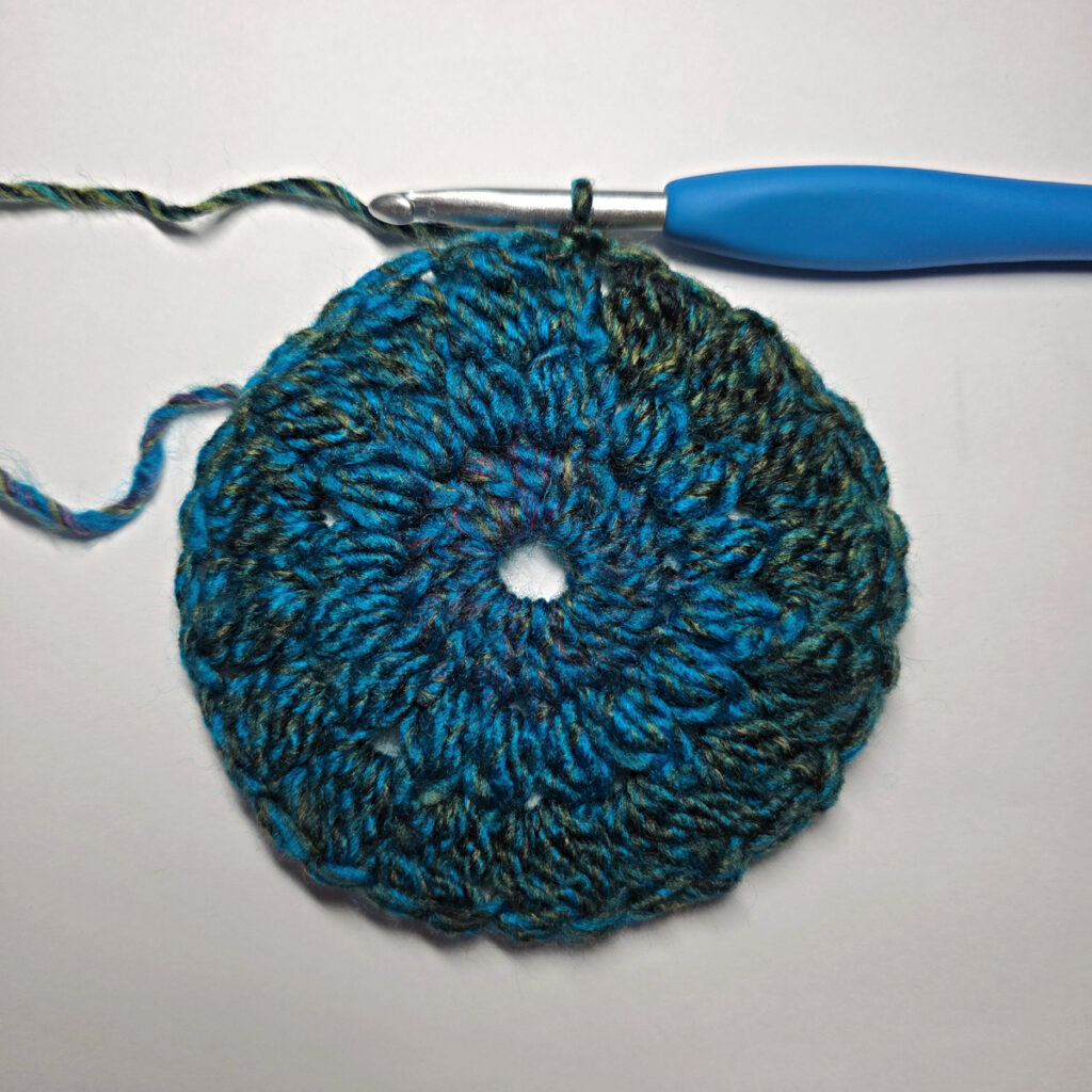 How to work a crochet floral square with a blue crochet hook.