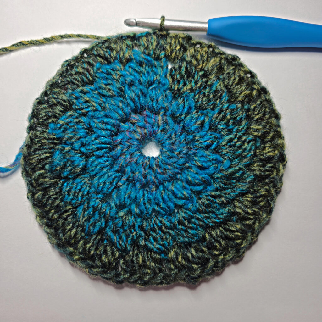 How to work a crochet floral square with a blue crochet hook.