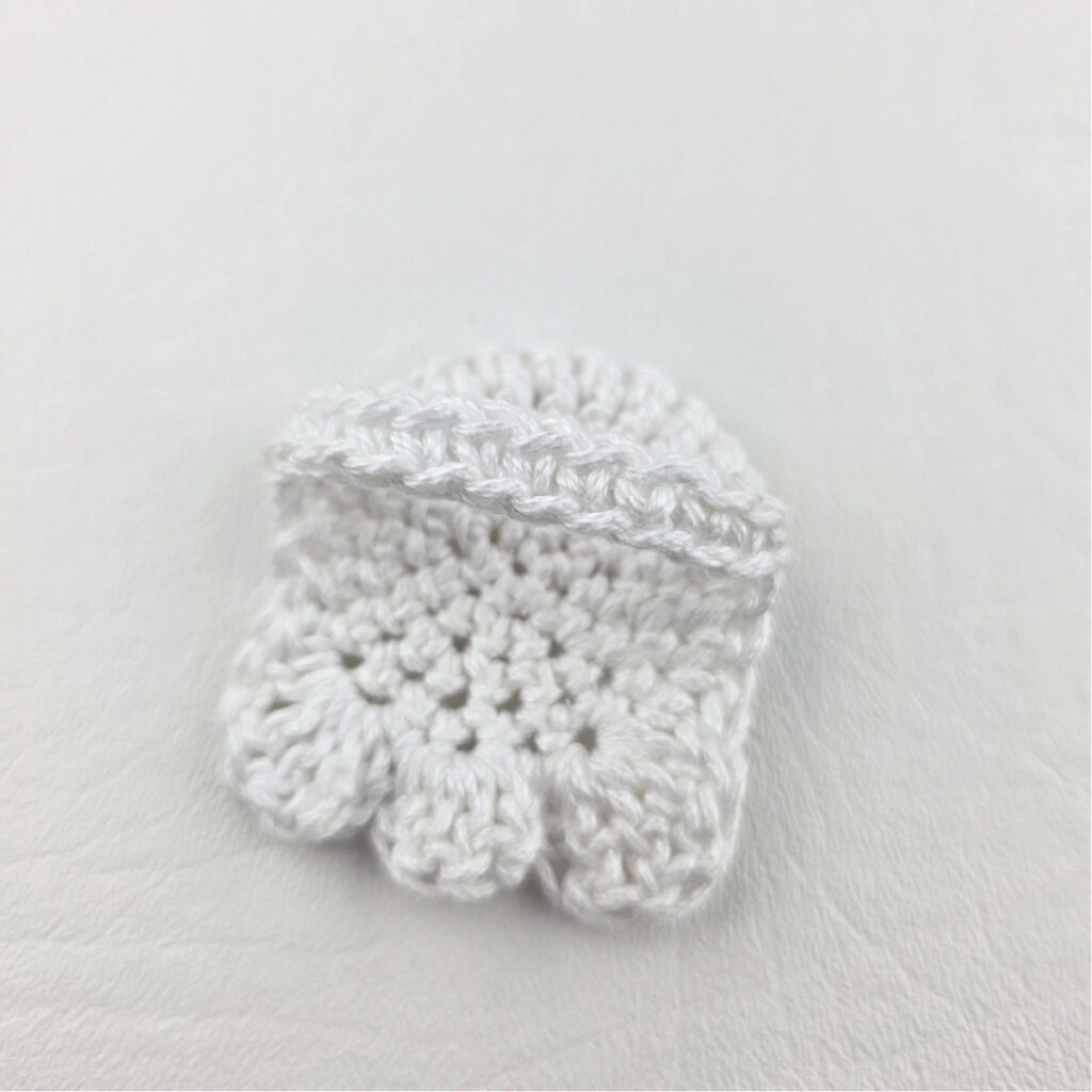 A completed white crochet ghost bookmark.