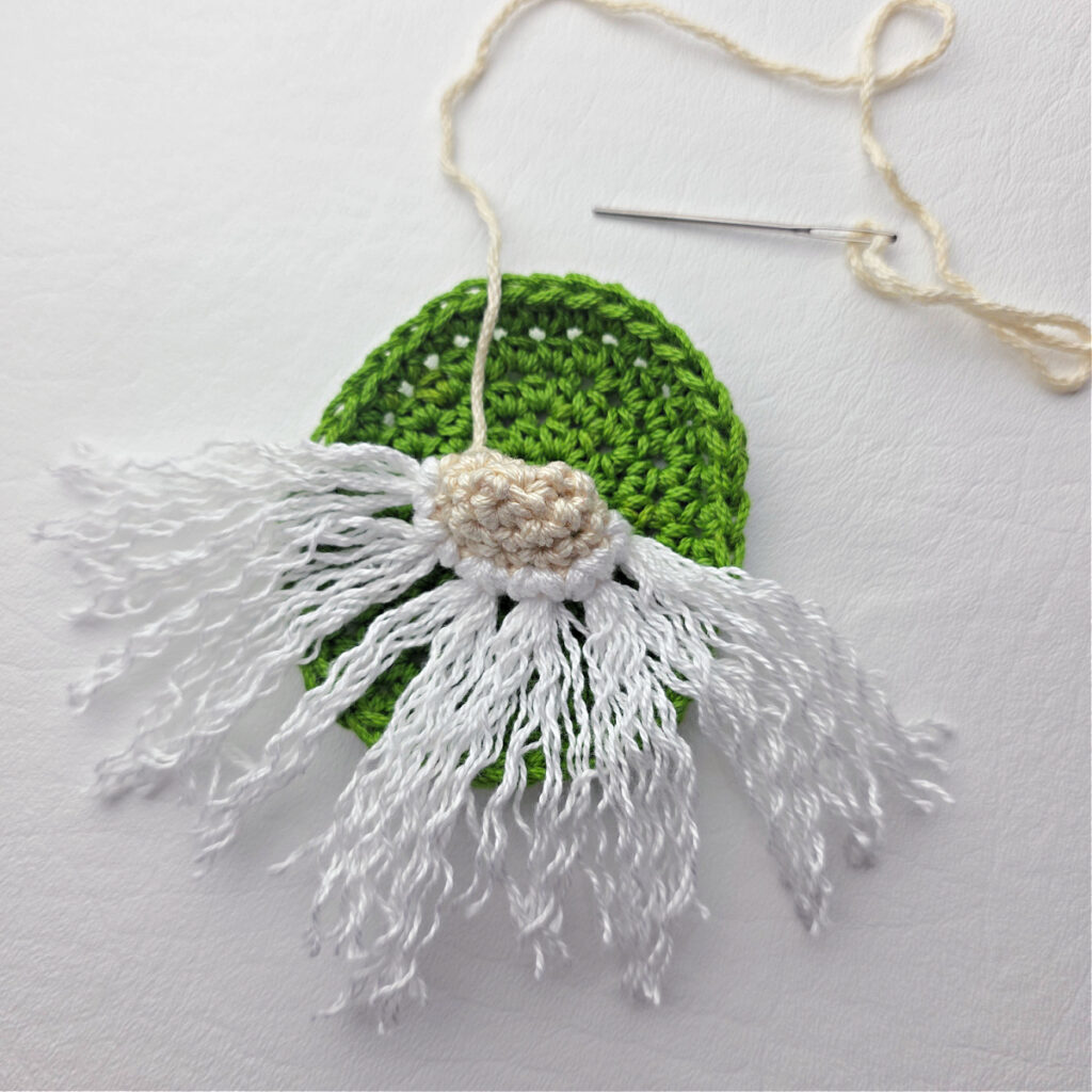 Attaching the beard of a crochet gnome.