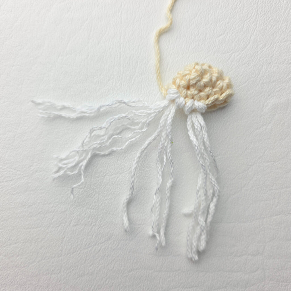 Attaching the beard of a crochet gnome.