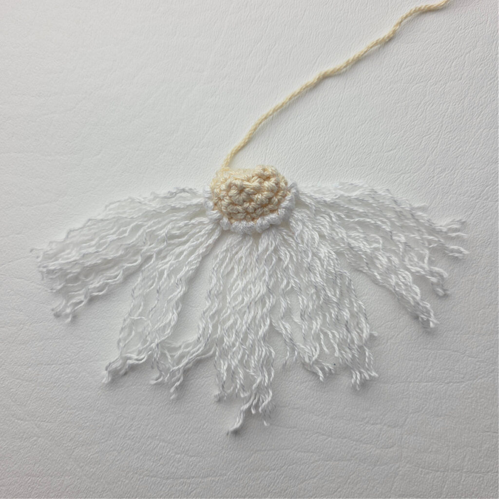 Attaching the beard of a crochet gnome.