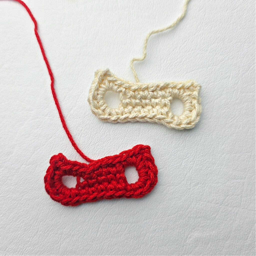 Two crochet mitten holders against a white background.