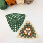 Solid green and multicolored crochet granny triangles on a white background with balls of yarn in the corner.