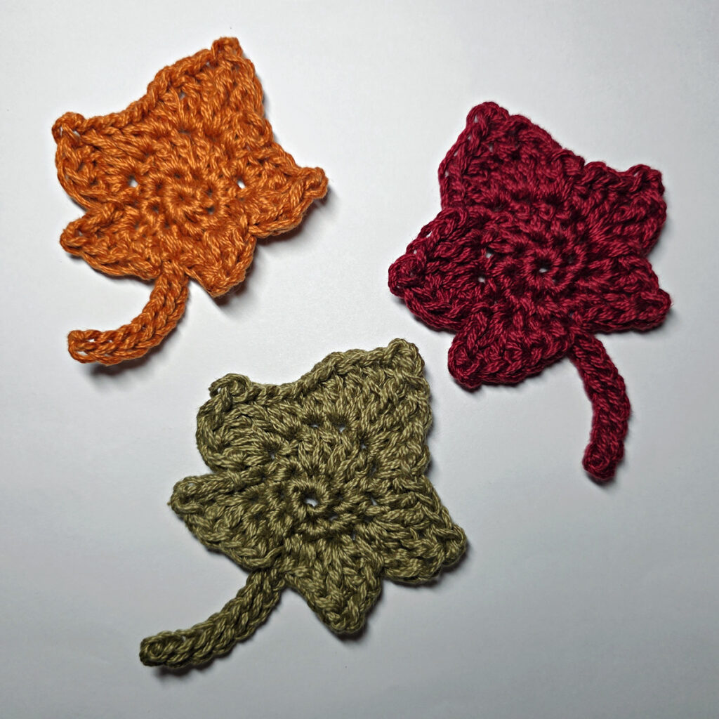 Three completed crochet maple leaves.