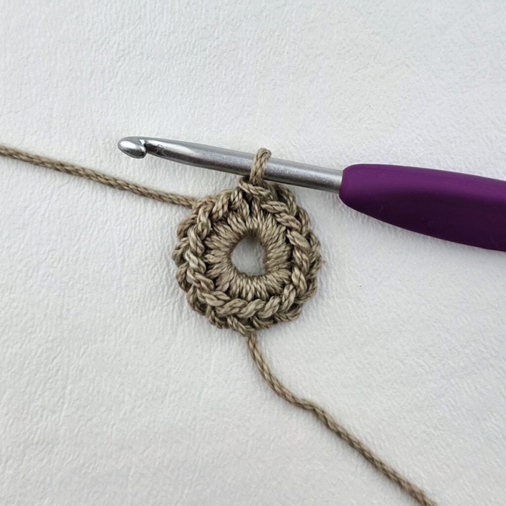 Round 1 of a crochet granny square motif.