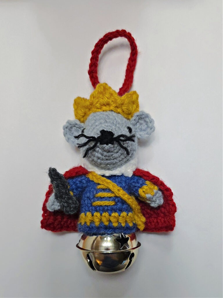 A crochet mouse king ornament complete with a little sword.