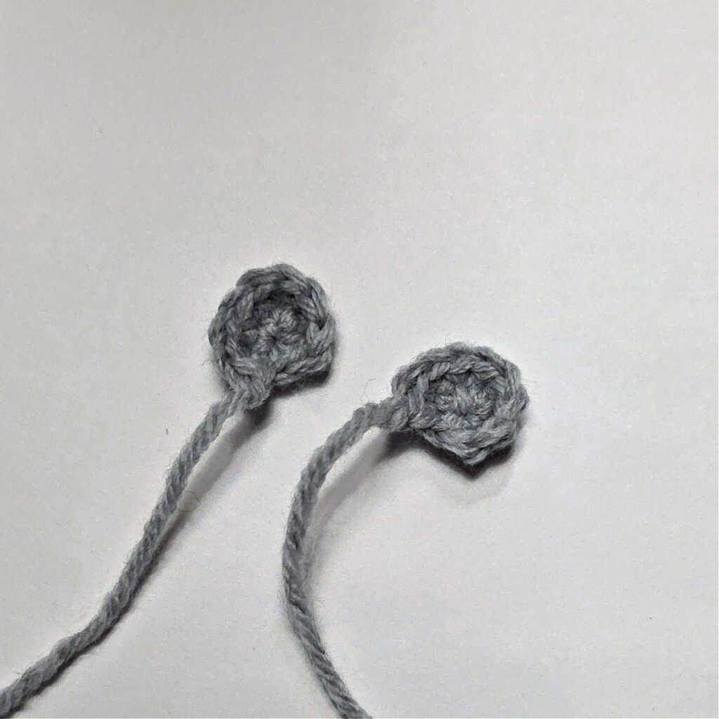 Two small grey crocheted ears for a mouse ornament.