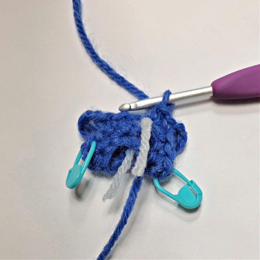 The body of the mouse being made in blue yarn.