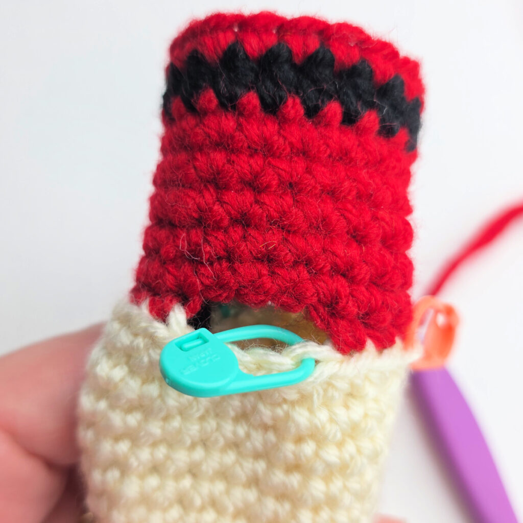 A close-up photo showing the stitch marked to join yarn for the nutcracker's arm.