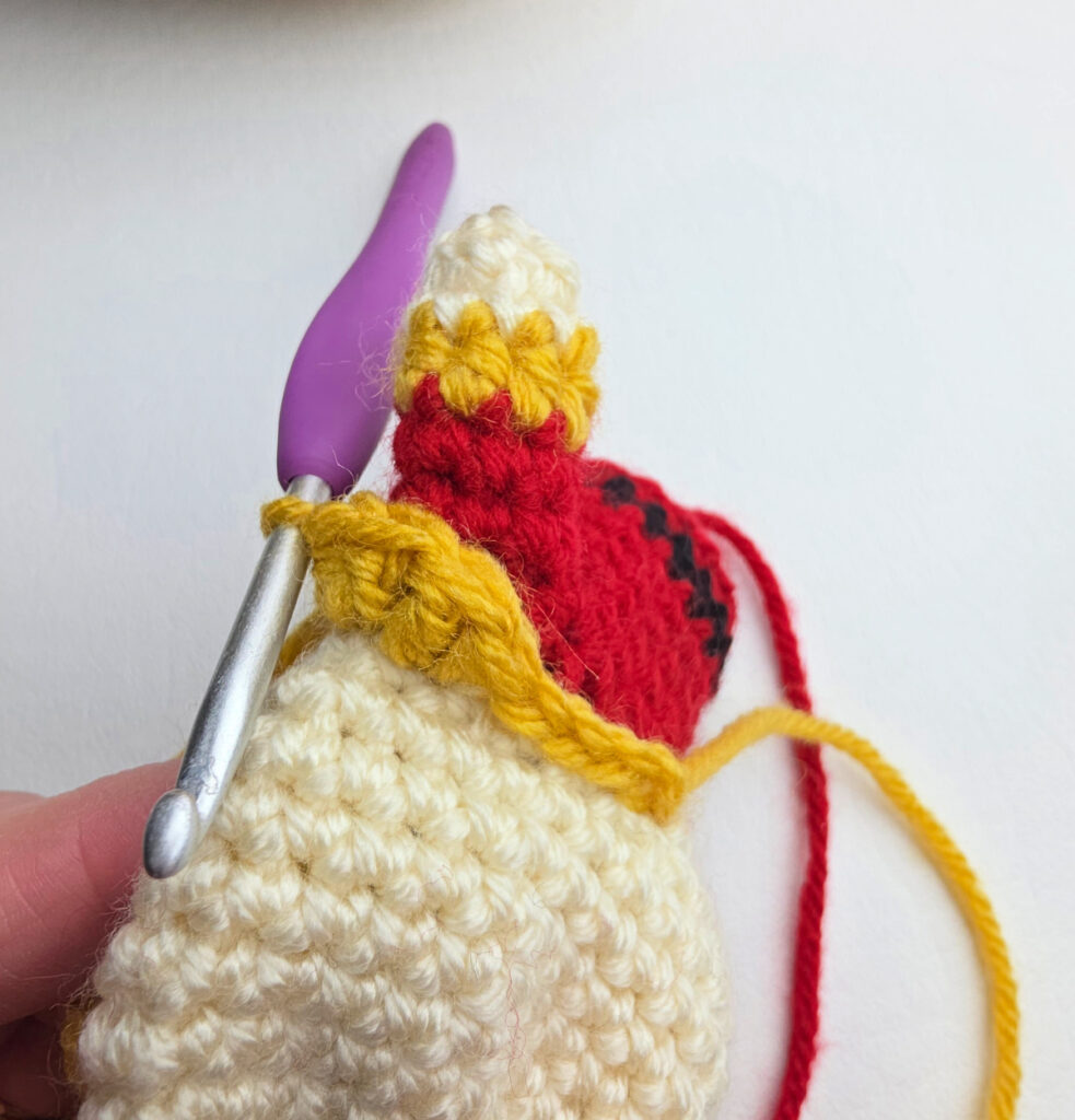 A purple crochet hook used to crochet the collar on a nutcracker.