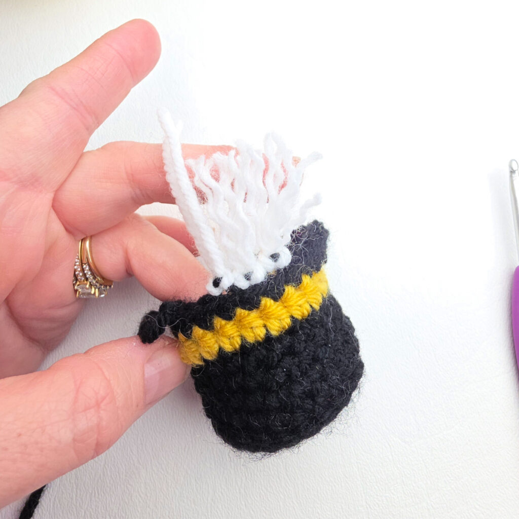 Close-up showing how yarn fringe is added to the nutcracker's hat to make hair.