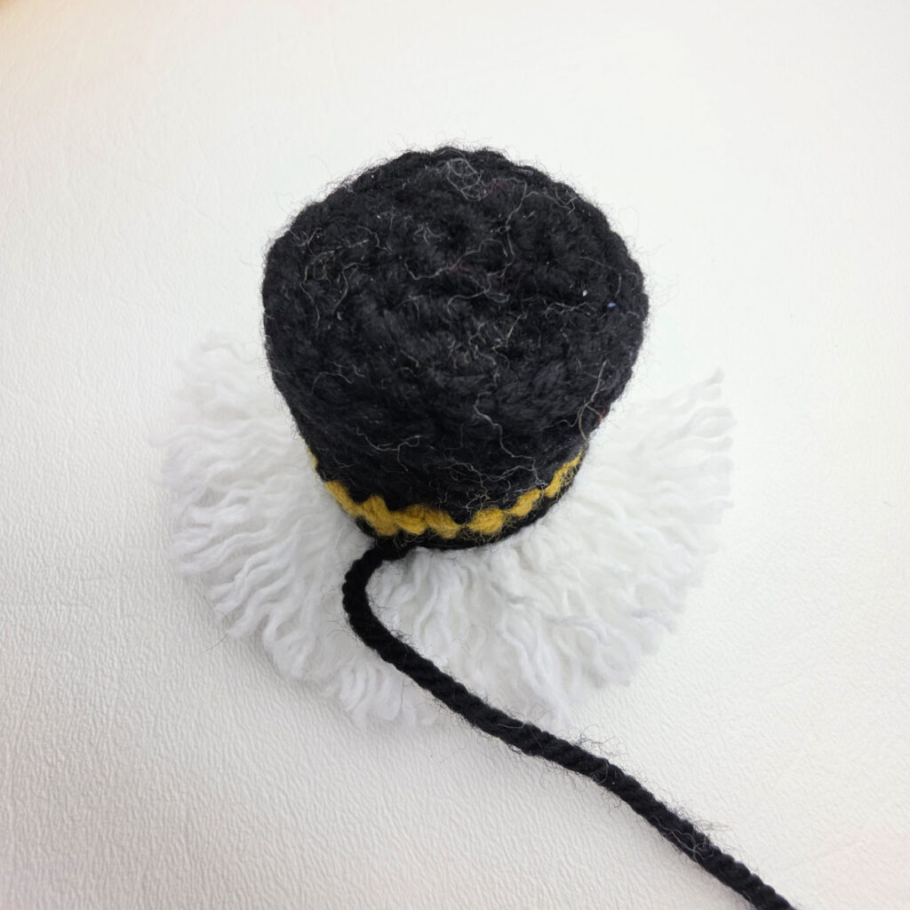 Top view of the crochet Nutcracker hat with white yarn hair attached like fringe.