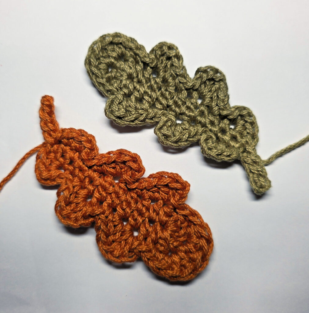 Two completed crochet oak leaves.