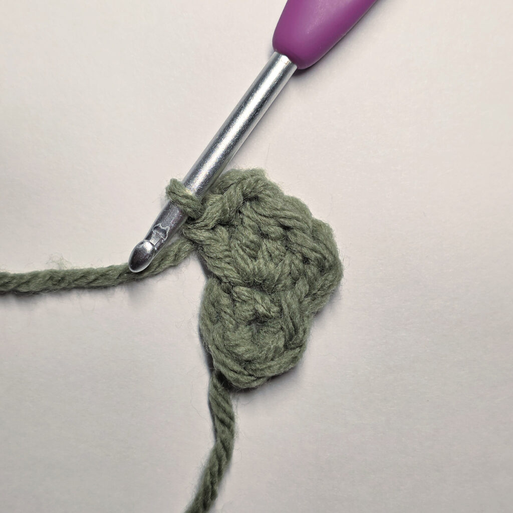 Working a green leaf with a purple crochet hook.