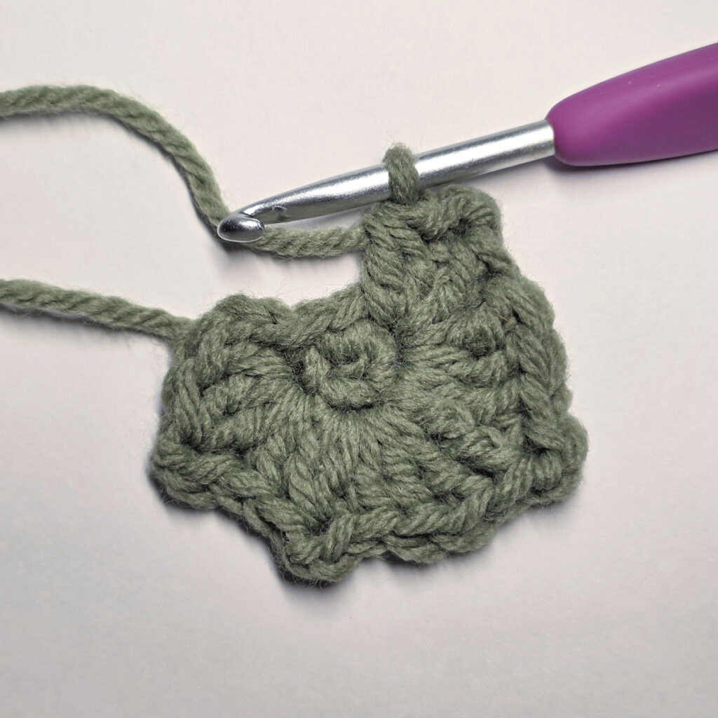 Working a green leaf with a purple crochet hook.