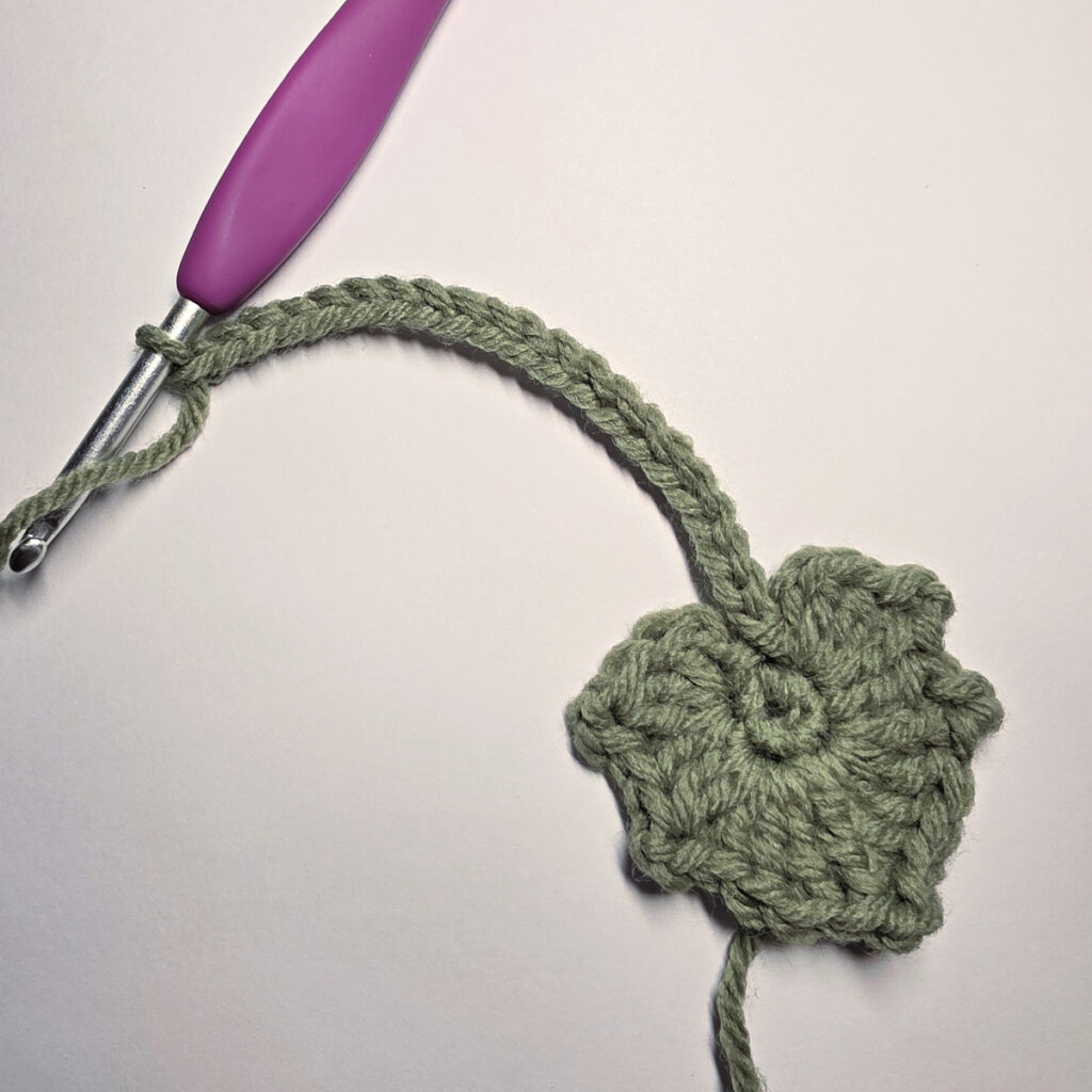 Working a green leaf with a purple crochet hook.