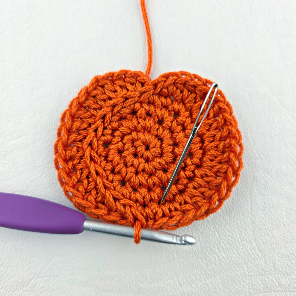 Making a small crochet pumpkin.