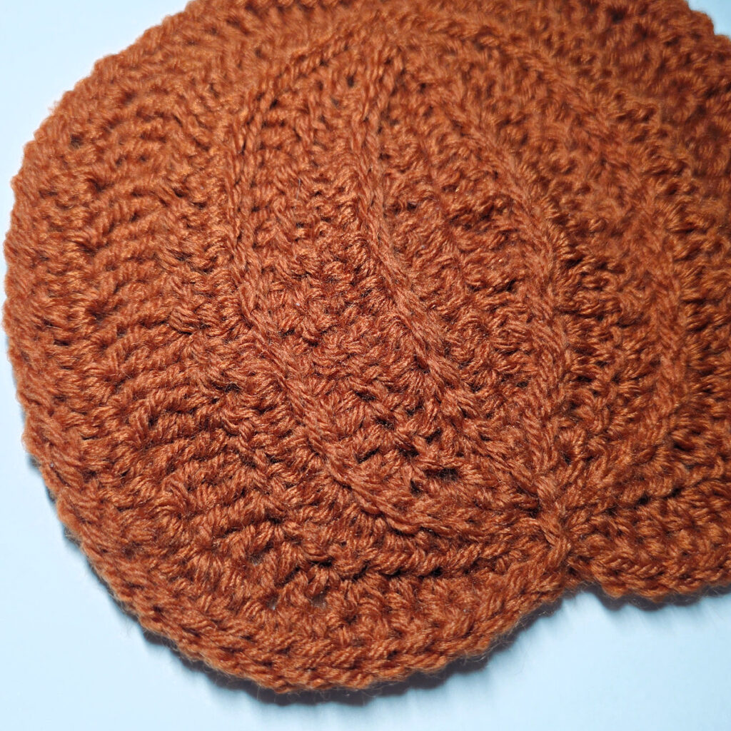Closeup of an orange crochet pumpkin.
