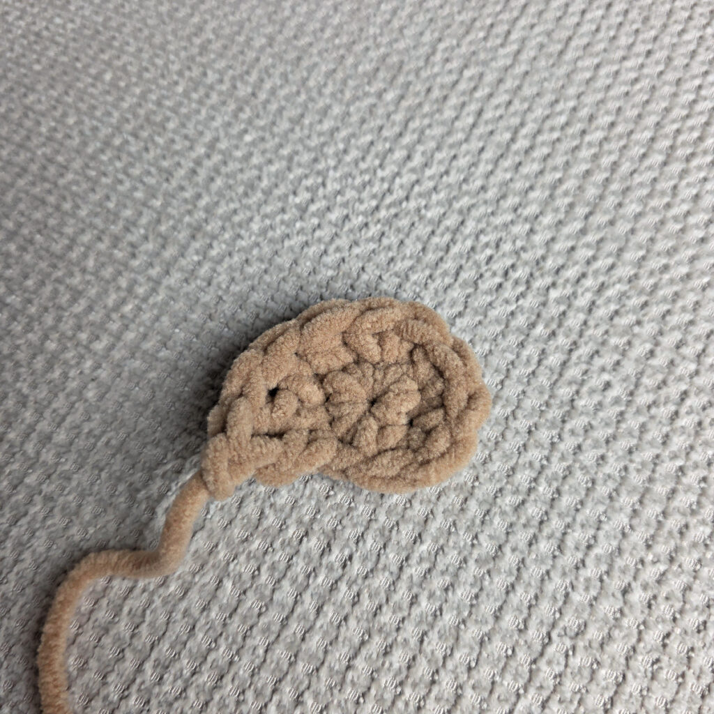 The brown eye patch of a crochet dog.