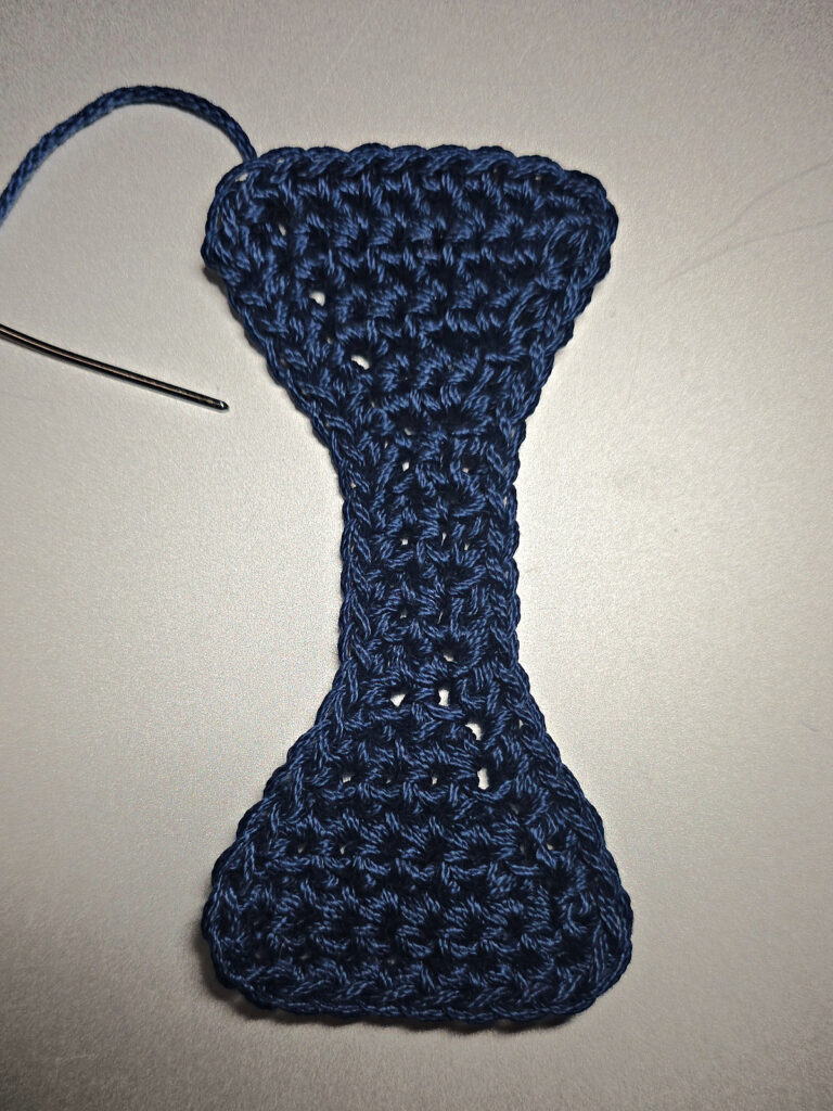 A blue crochet strap connector.