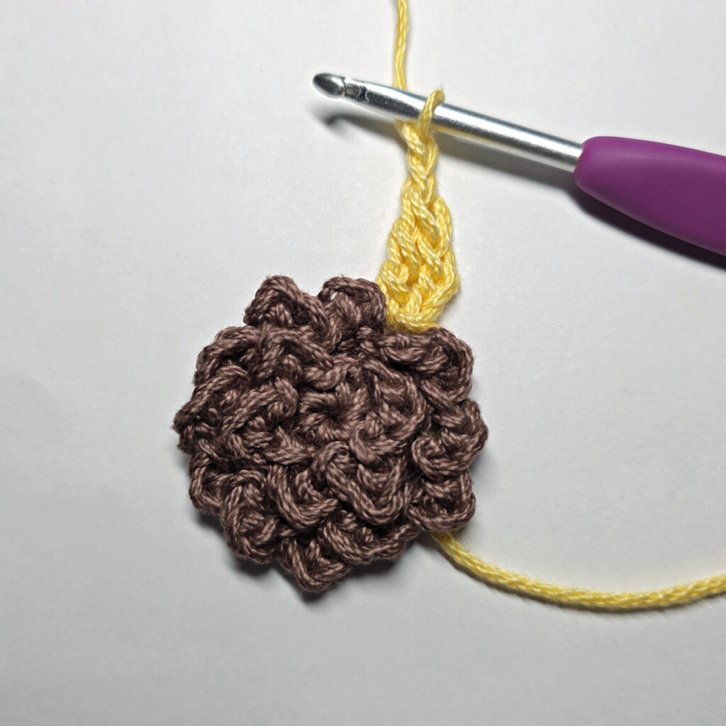 Making a crochet sunflower applique.